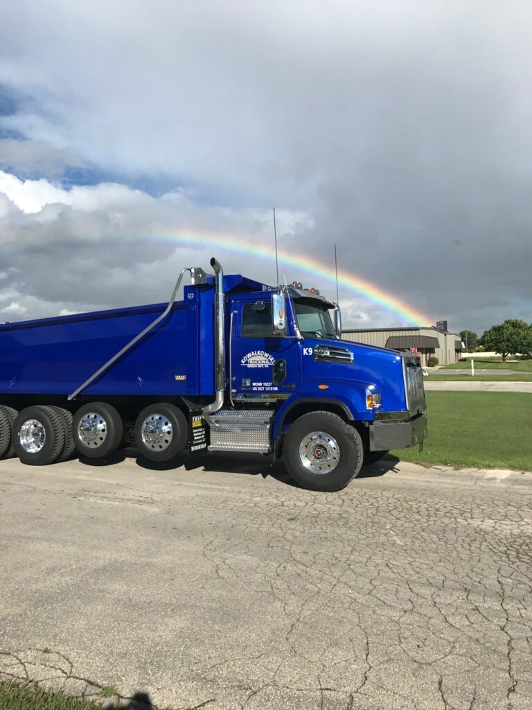 One Red-D-Mix Concrete dump truck in front of a rainbow